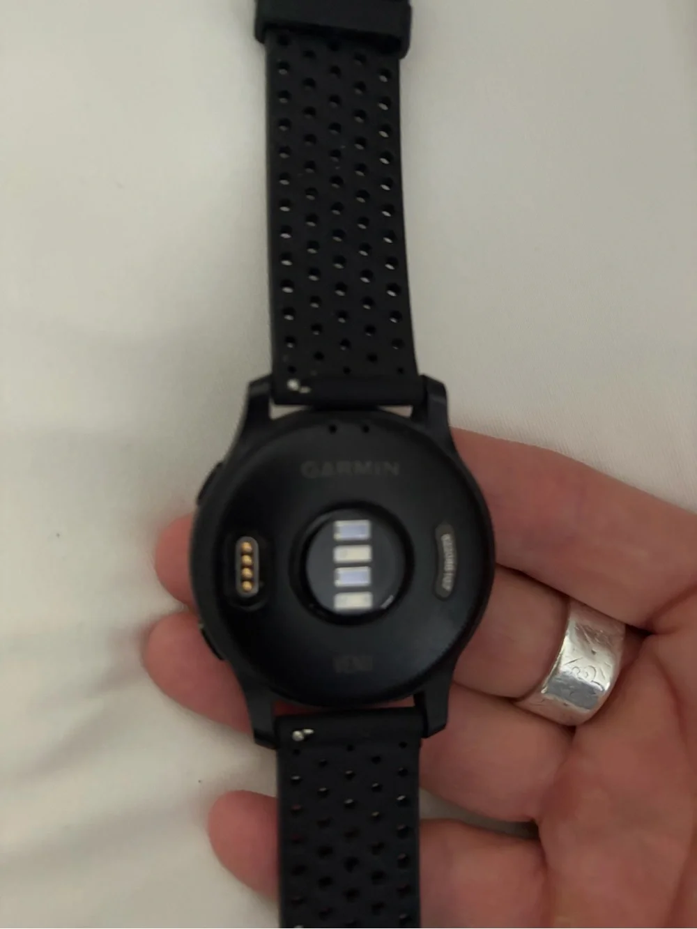 garmin black perforated silicone sport smartwatch with round digital display